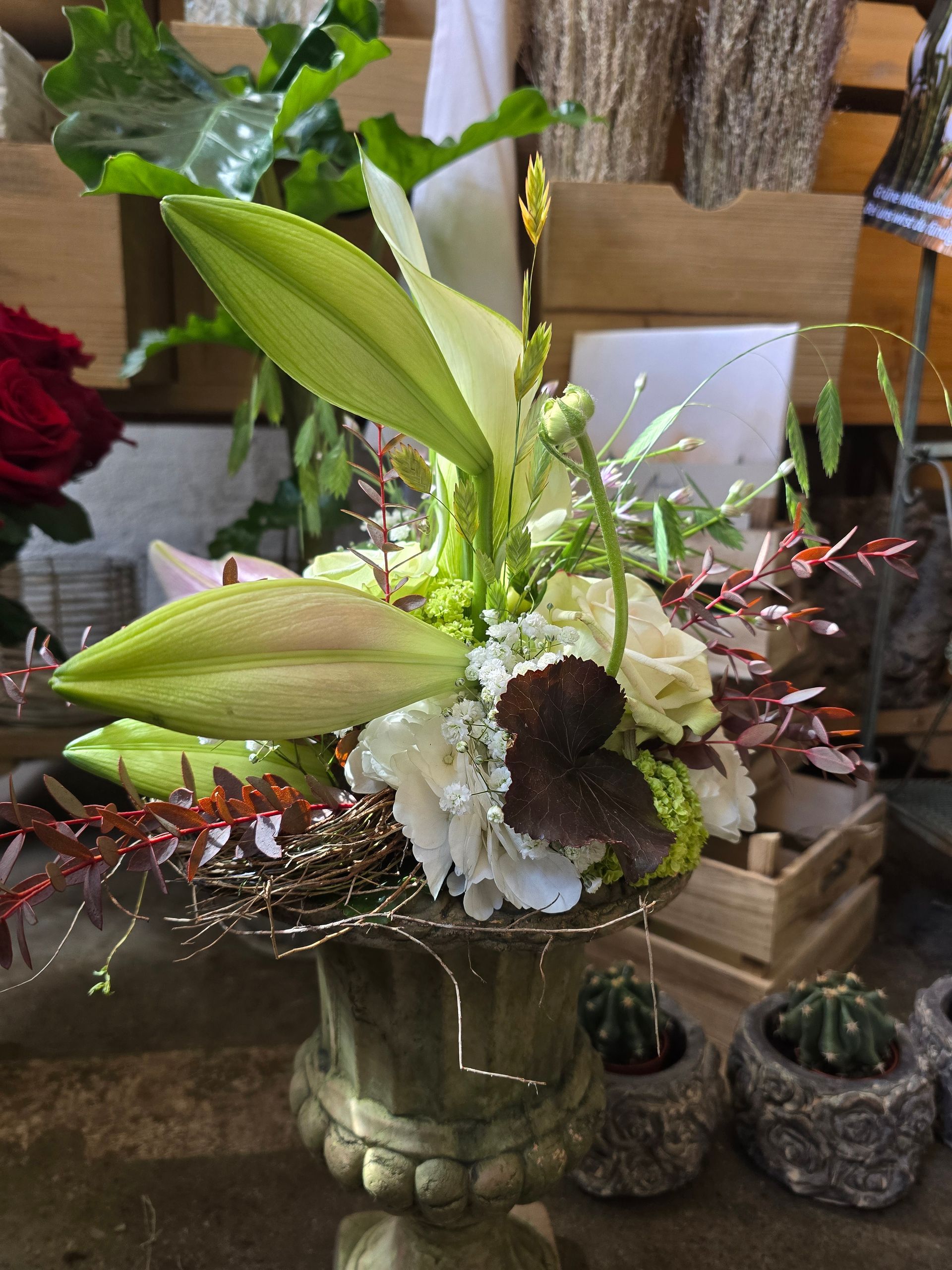 Auf einem Tisch steht eine mit Blumen gefüllte Vase.