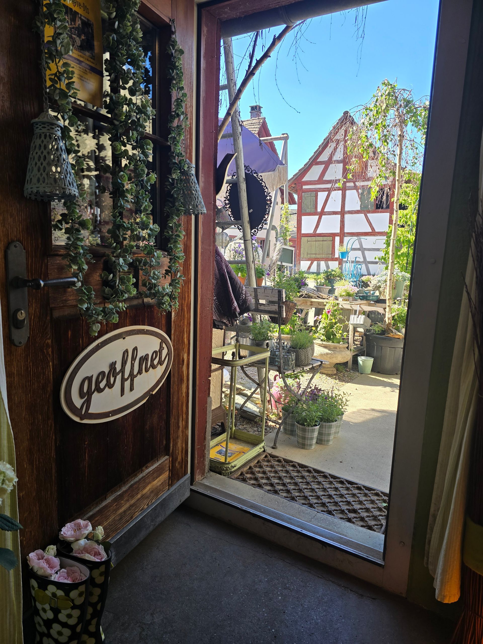 Eine Kerze steht auf einem Teller auf einem Tisch, umgeben von Blumen.
