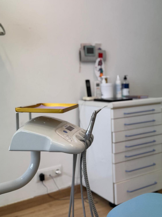 Una silla dental en un consultorio dental con una bandeja amarilla encima.