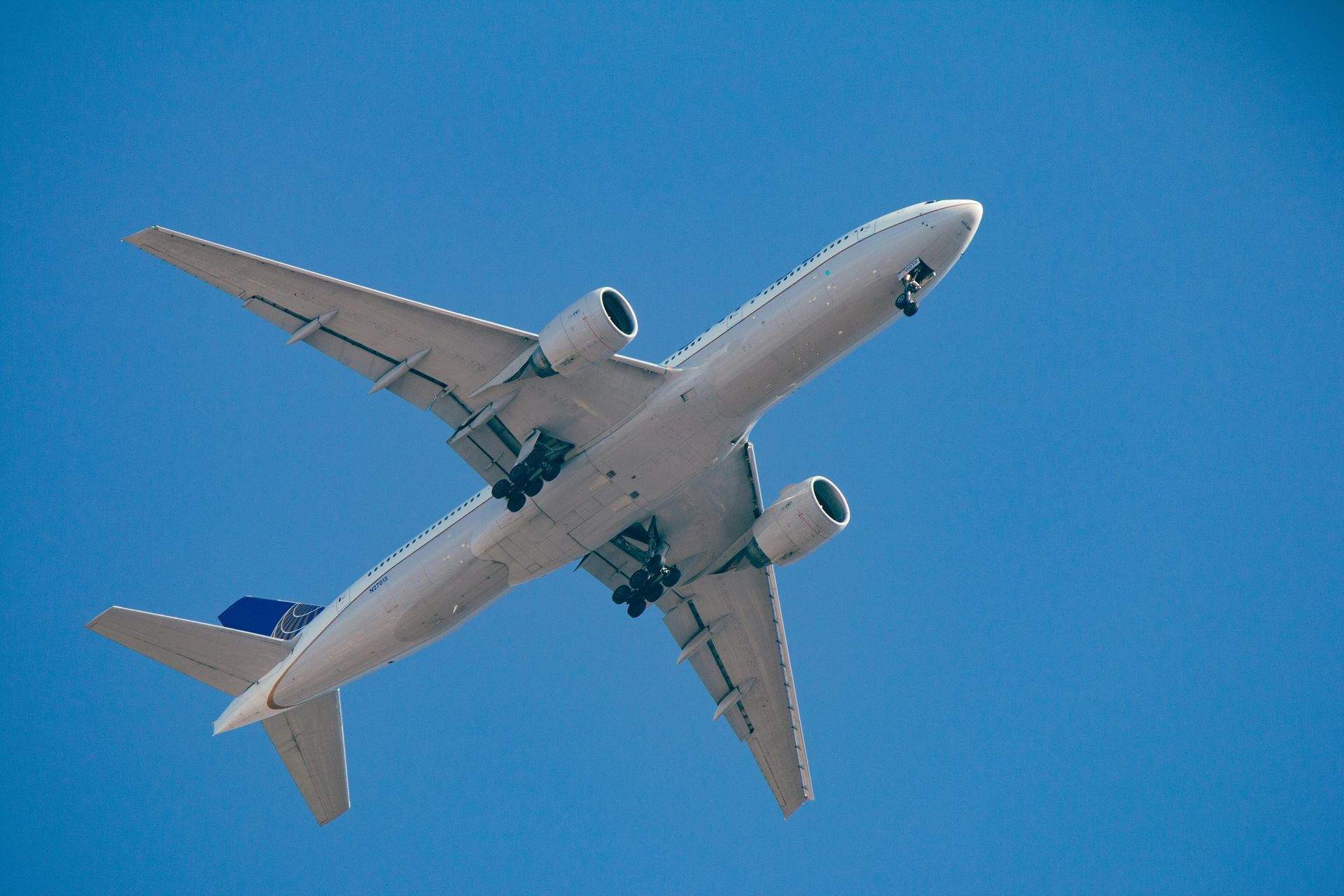 Un avión sobrevolando contra un cielo azul despejado