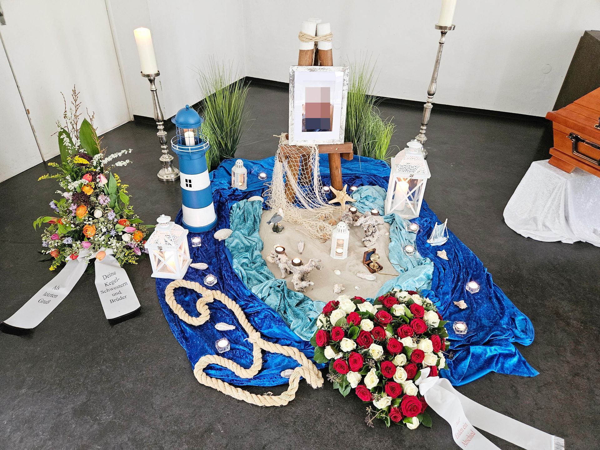 Ein Tisch mit Blumen, Kerzen und einem Leuchtturm darauf