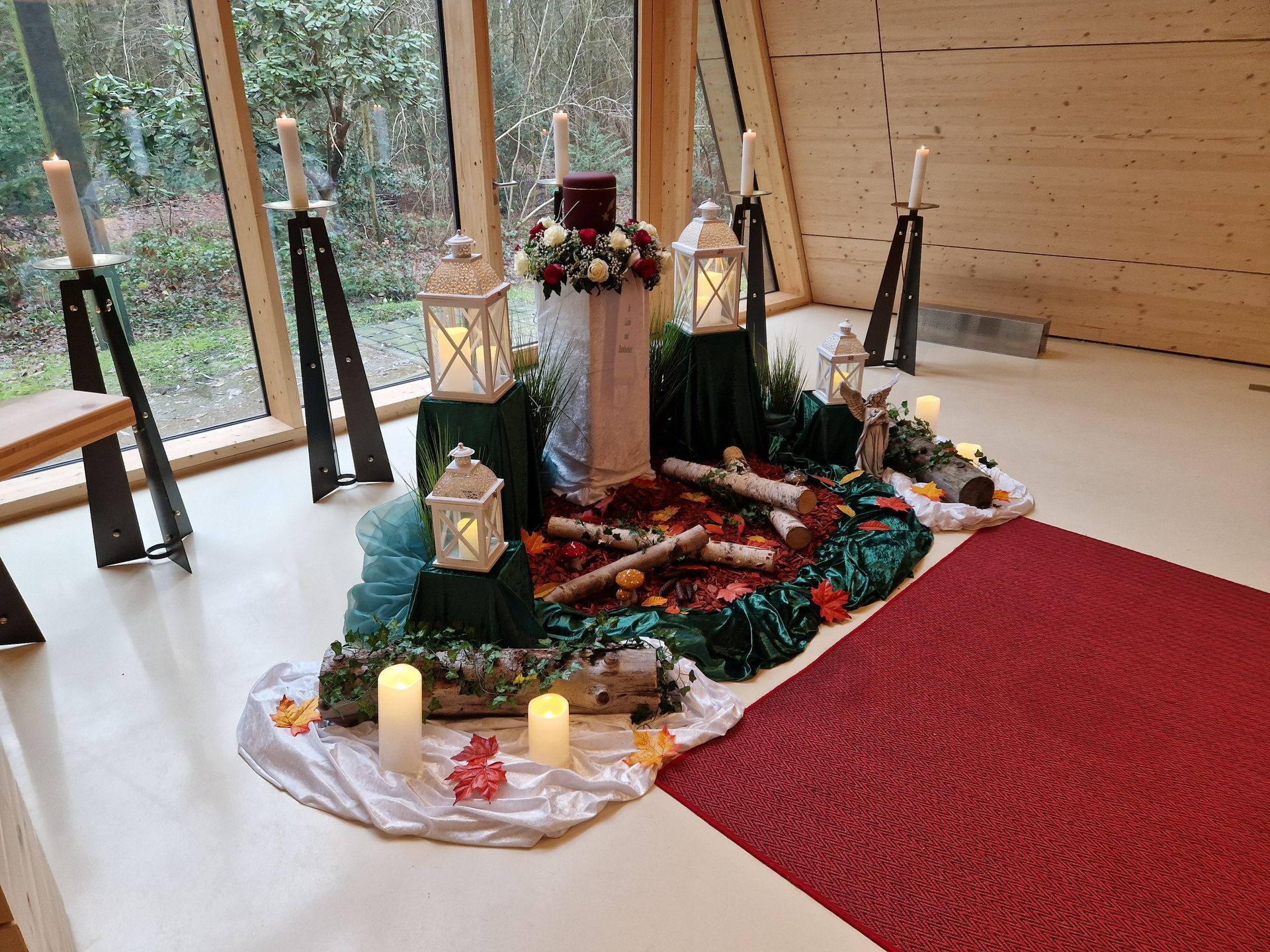 Ein Raum mit Kerzen, Laternen und Blumen auf dem Boden.