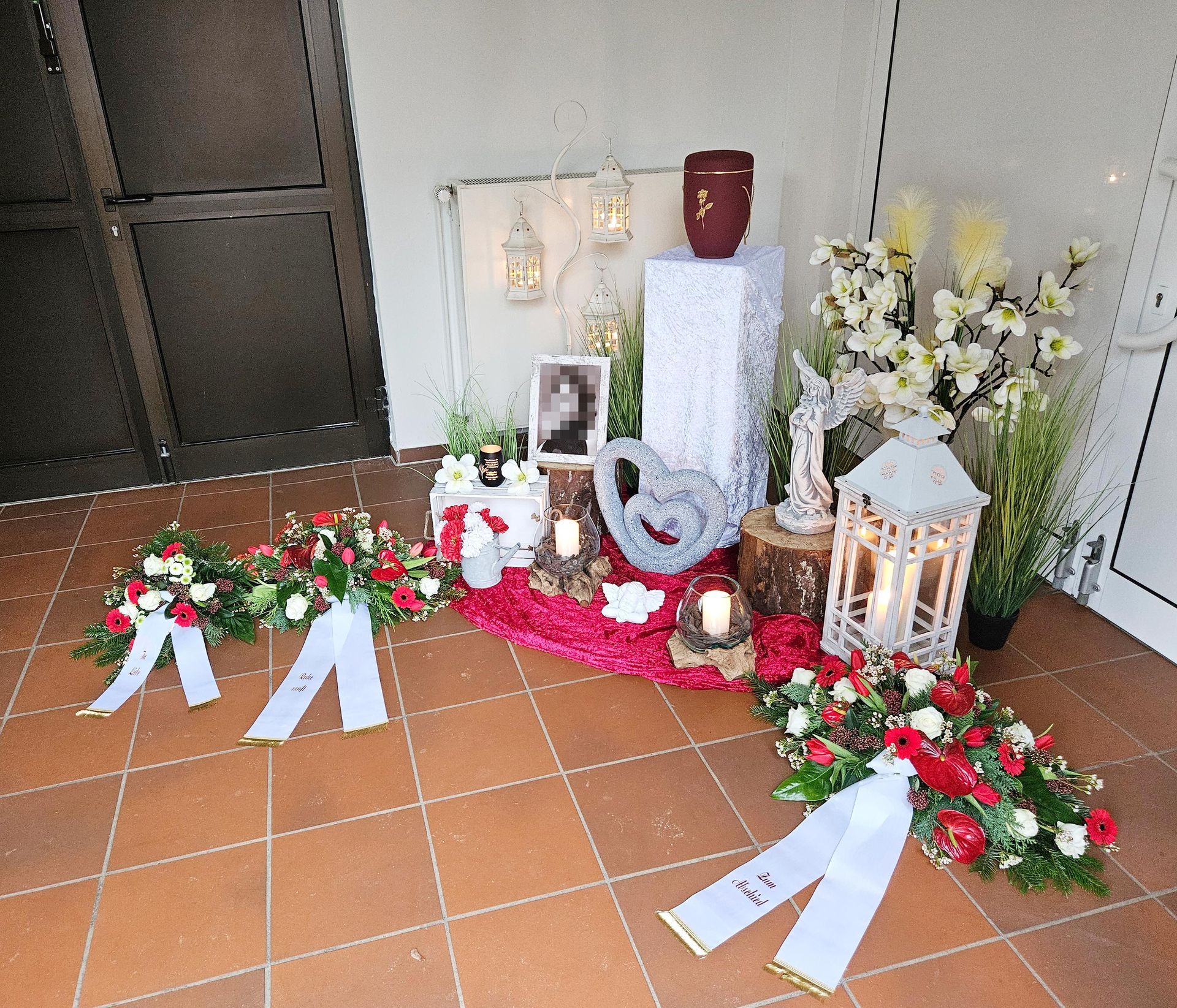 Ein Zimmer mit Blumen, Kerzen und einem Bild an der Wand