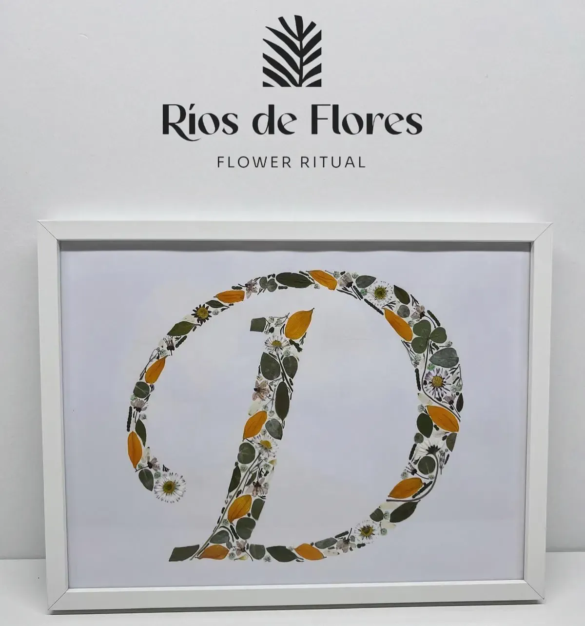 Un ramo de rosas rojas y vegetación sobre una superficie blanca, con el logo 