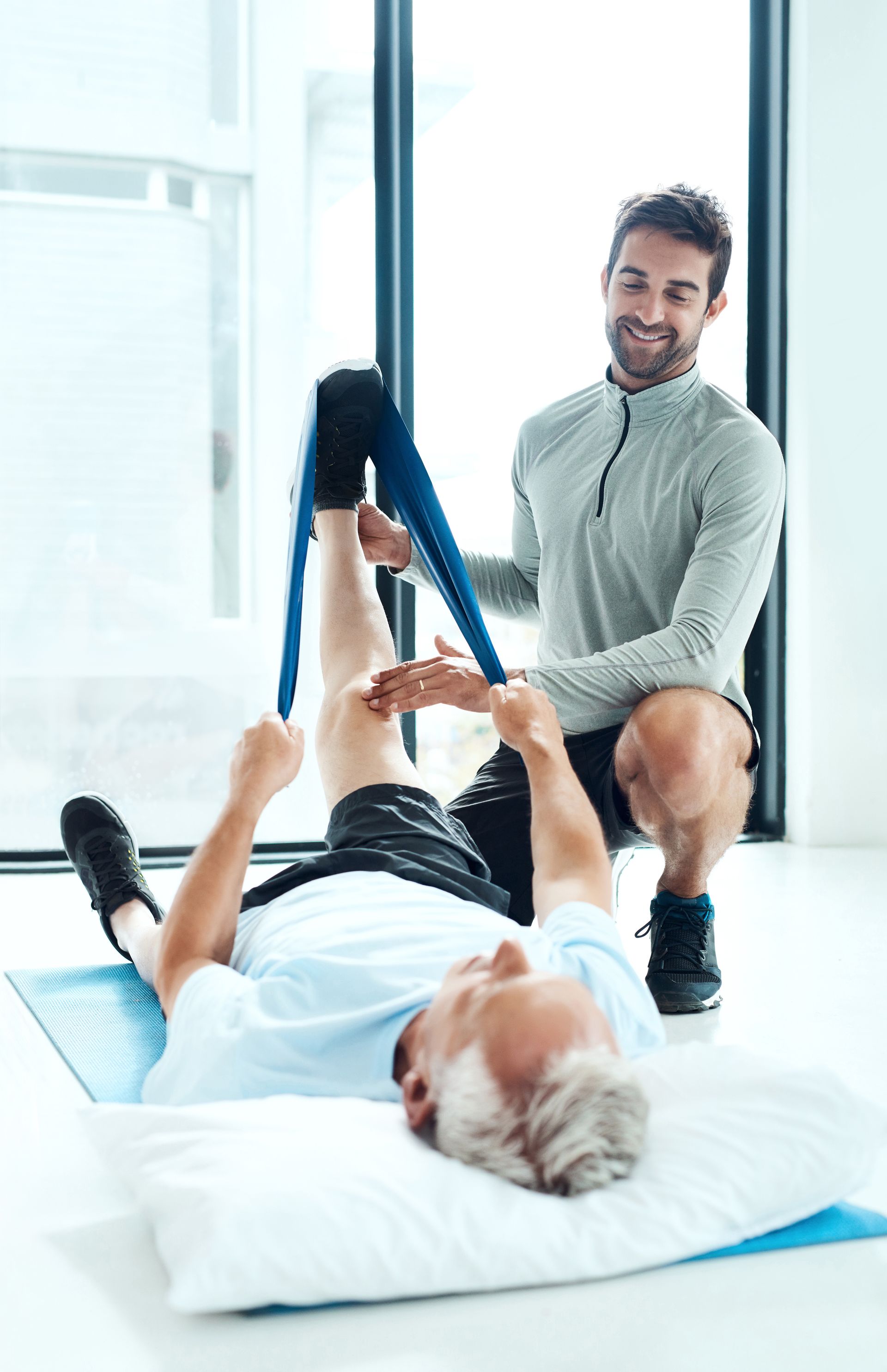 Ein Physiotherapeut untersucht die Schulter und den oberen Rücken eines Patienten auf Schmerzen oder Bewegungseinschränkungen.
