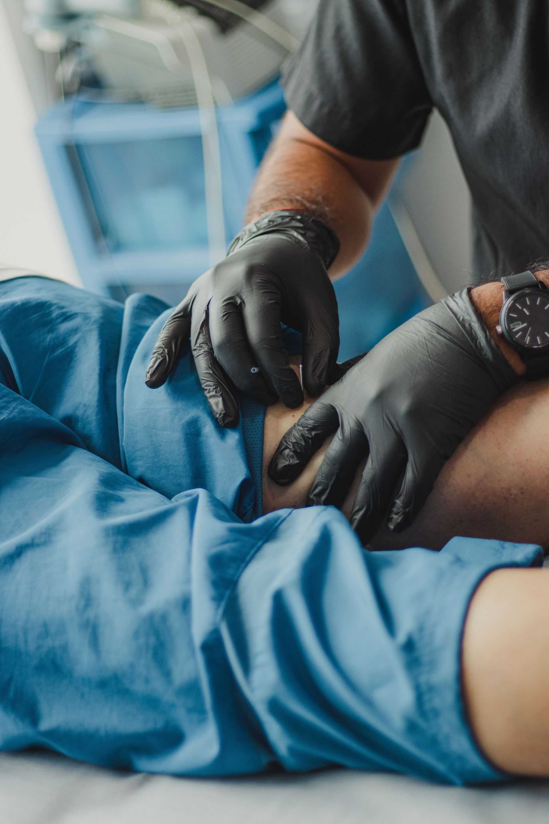 Mit behandschuhten Händen wird eine Injektion in die Haut eines Patienten verabreicht
