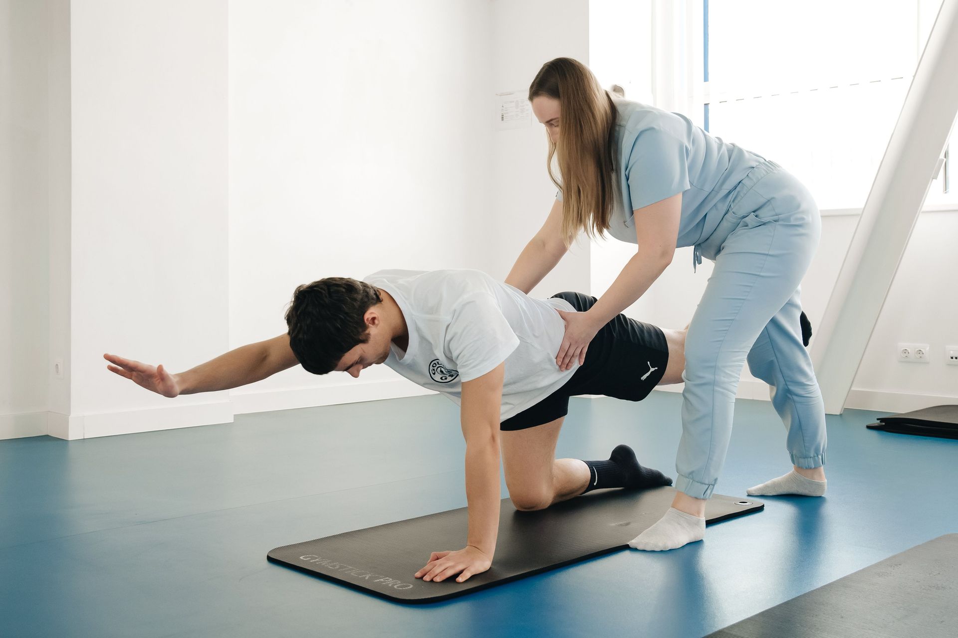 Ein Physiotherapeut untersucht die Schulter und den oberen Rücken eines Patienten auf Schmerzen oder Bewegungseinschränkungen.