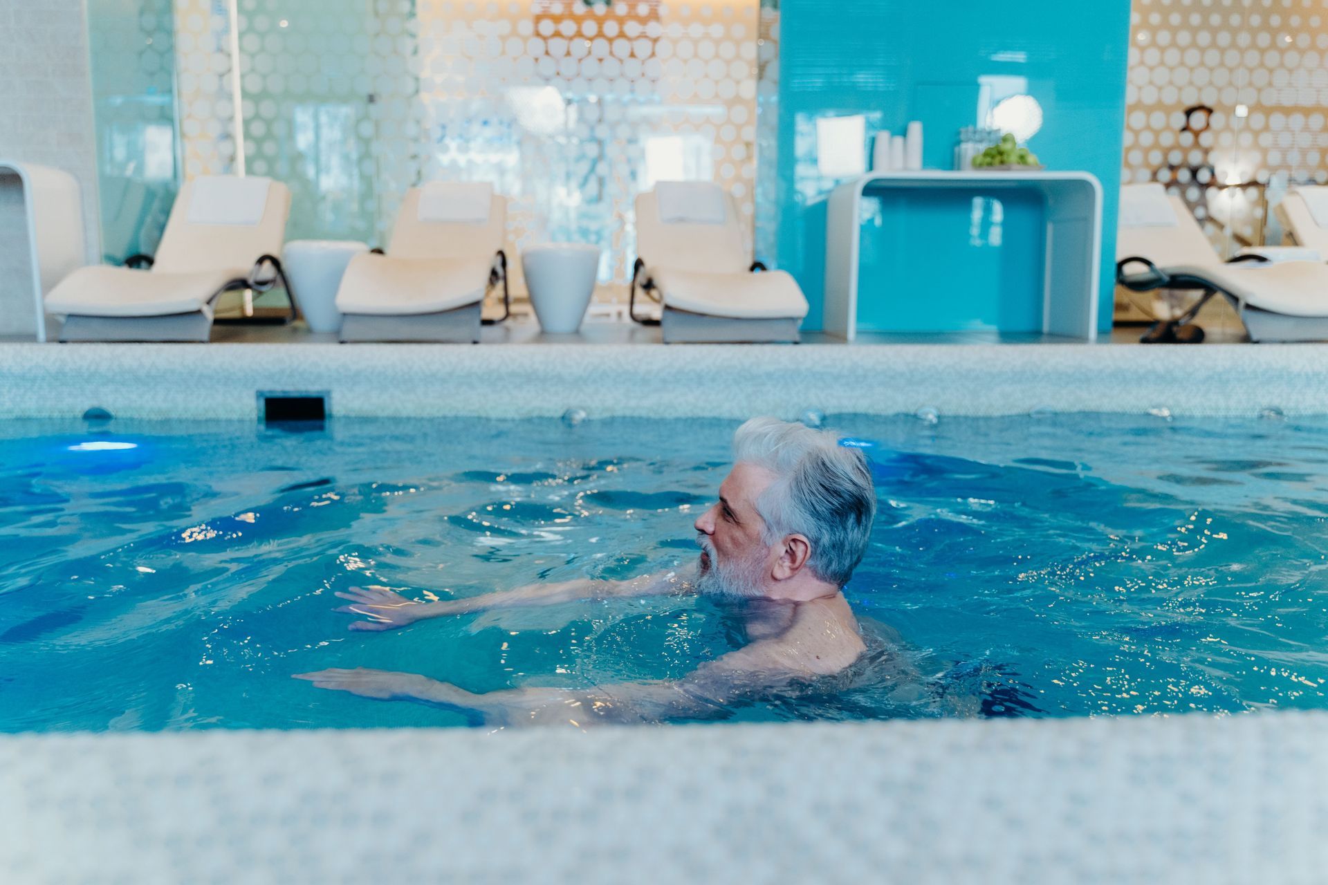 Ein Physiotherapeut dehnt in einer Klinik das Bein eines Patienten, während ein anderer Therapeut an einem Computer arbeitet.