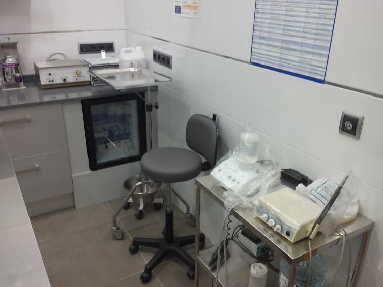 Un consultorio dental con un taburete y un lavabo.