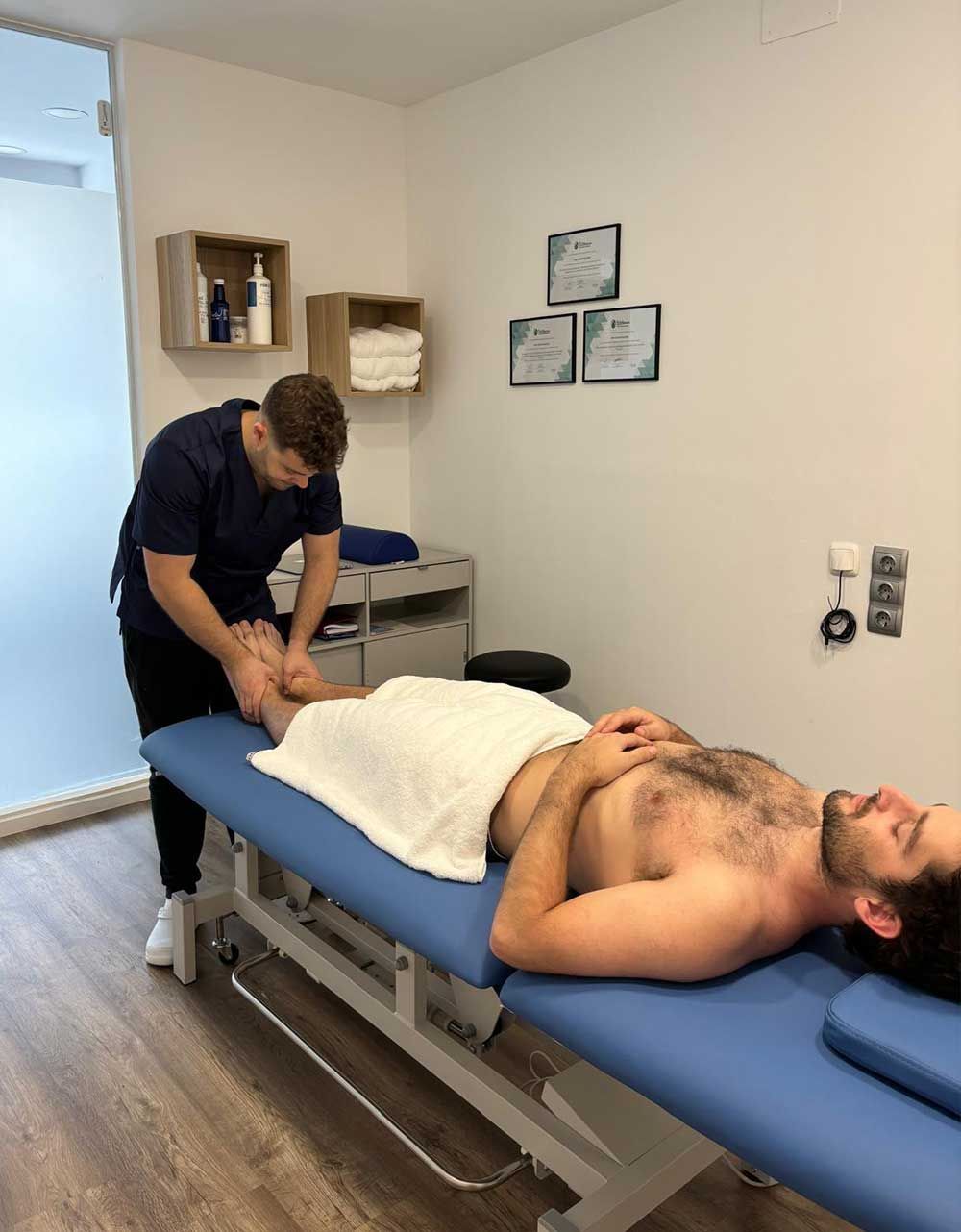 Un hombre está acostado en una mesa recibiendo un masaje.