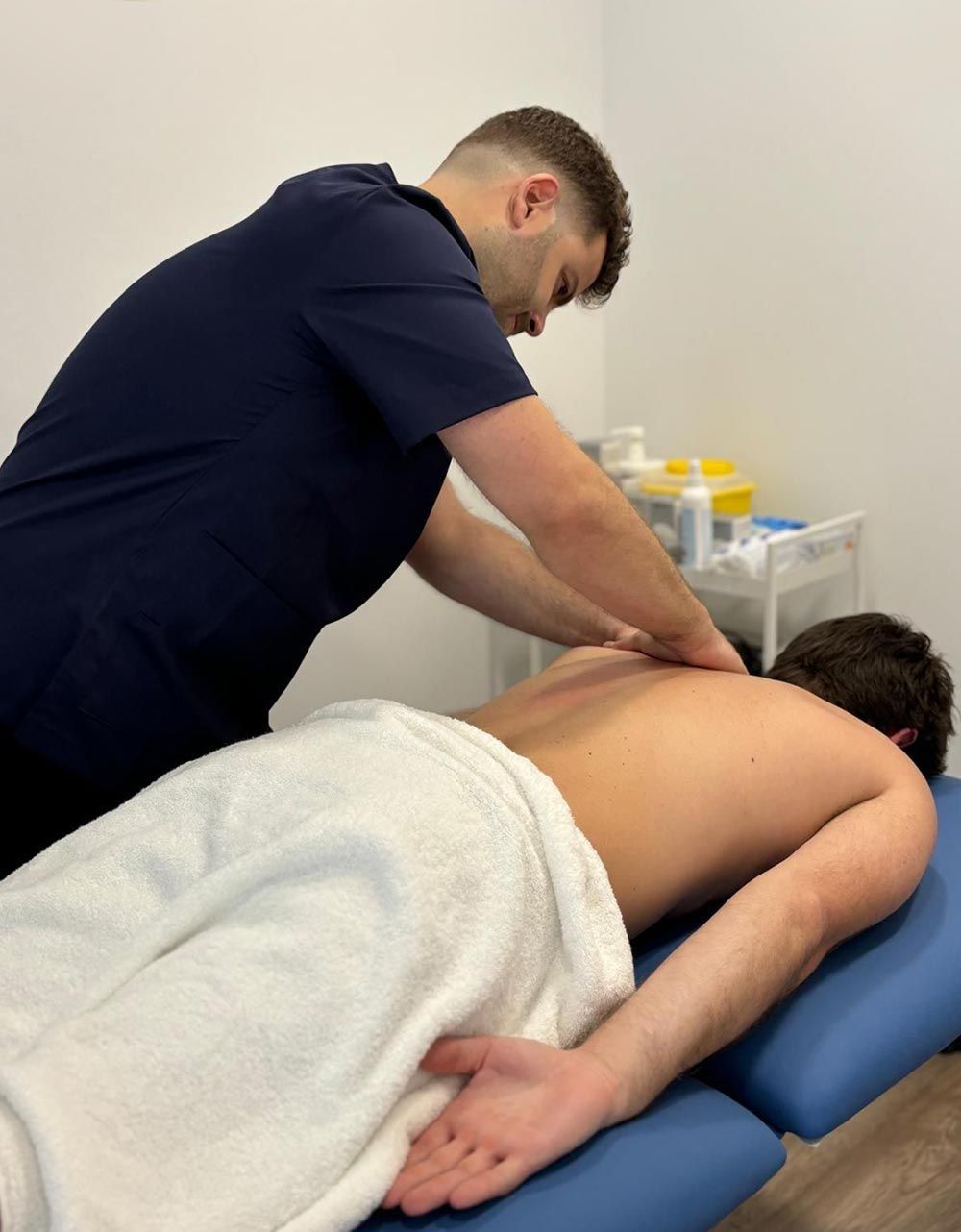 Un hombre le está dando un masaje a otro hombre en una mesa.