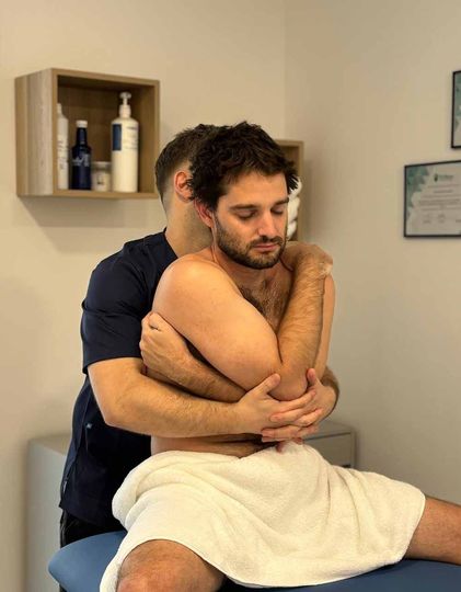 Un hombre con una toalla está recibiendo un masaje de otro hombre.
