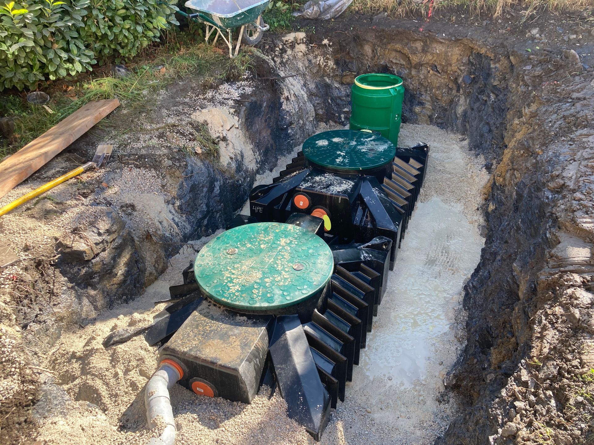 Fosse septique installée dans une tranchée, entourée de gravier.