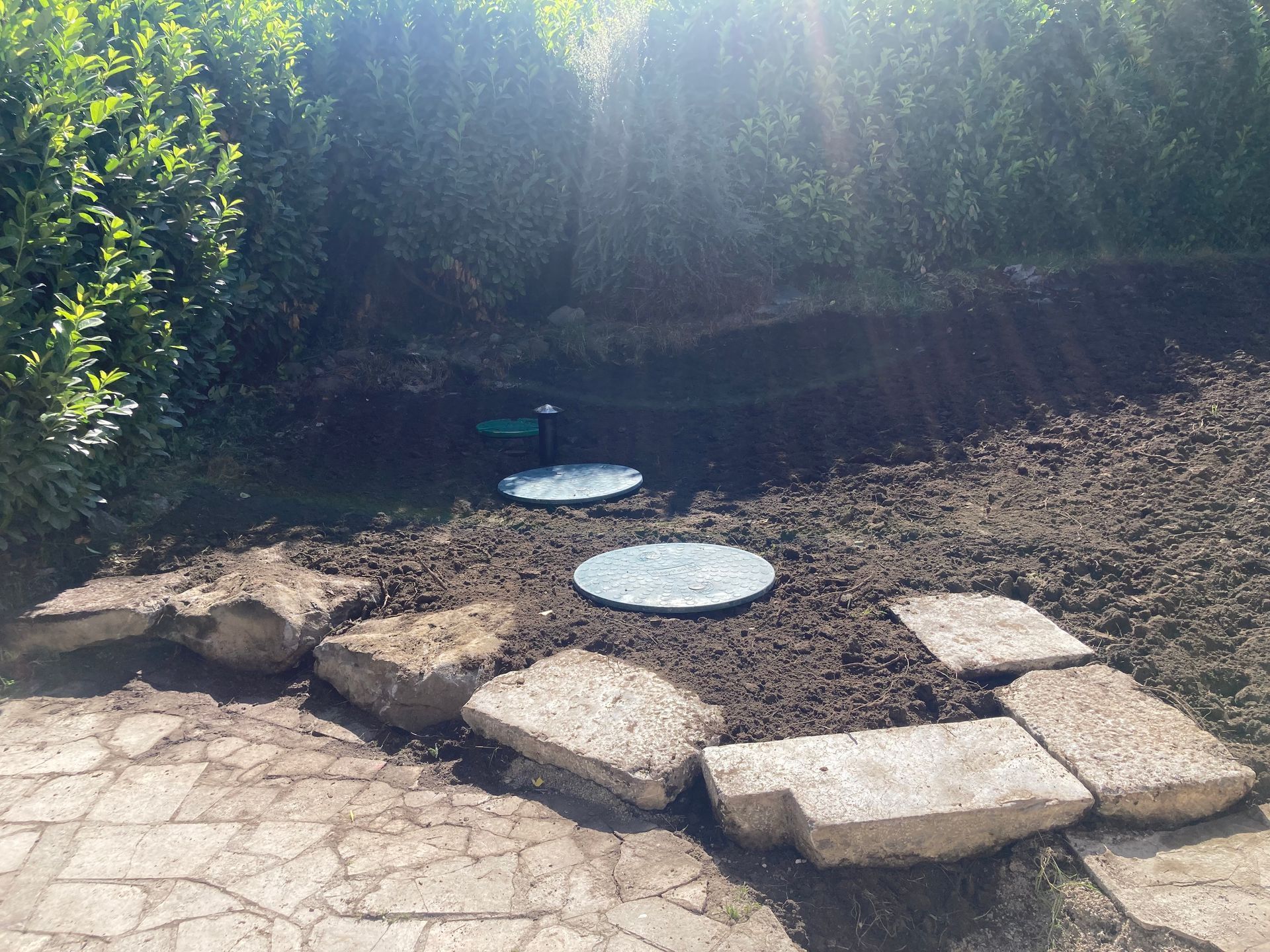 Cuve toutes eaux enterrée dans un jardin.