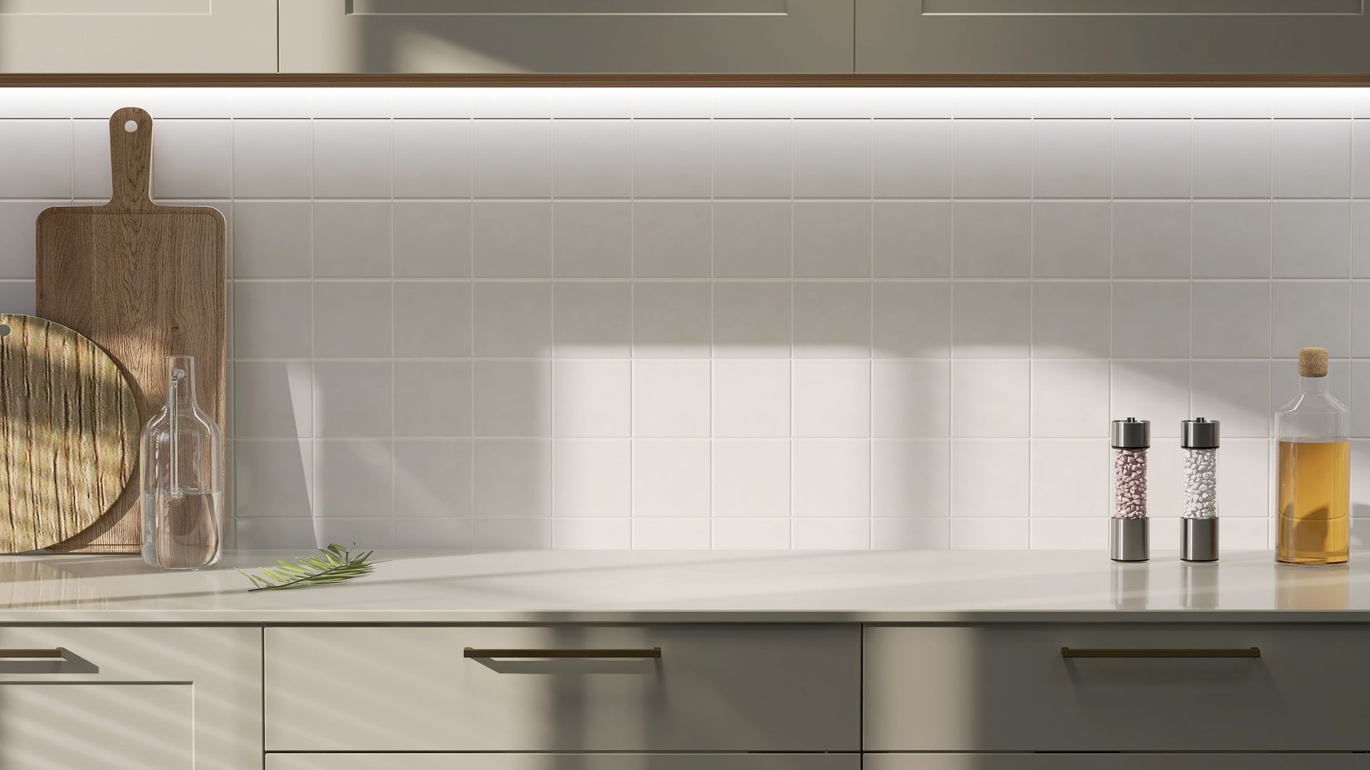 Plan de travail minimaliste blanc avec planches à découper, herbes aromatiques et bouteilles d'huile près d'une crédence carrelée