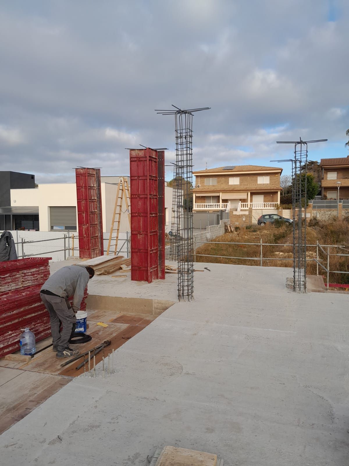 Un hombre está trabajando en un piso de concreto en un sitio de construcción.