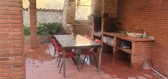 Un edificio de ladrillo con una mesa y sillas delante.