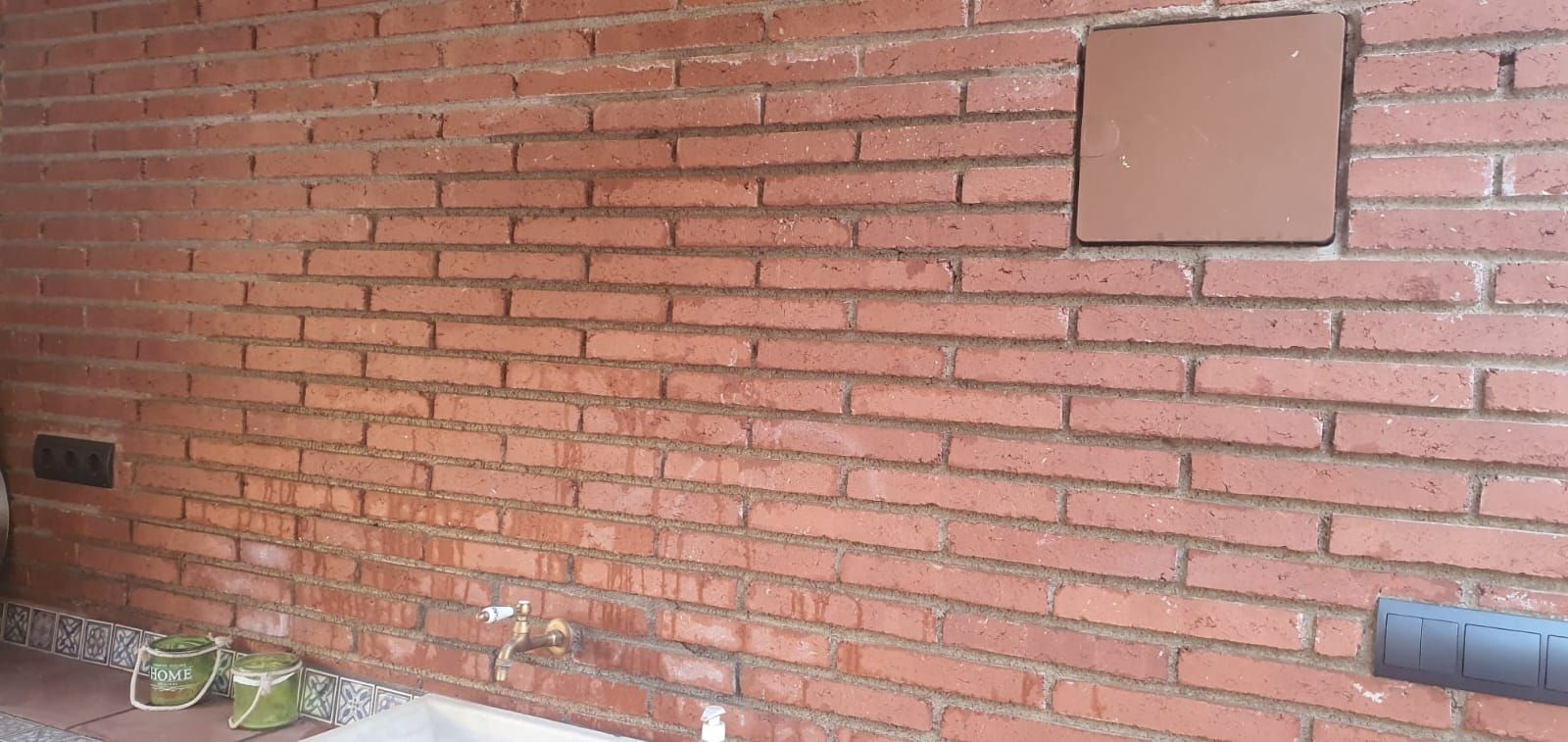 Un primer plano de una pared de ladrillos con un agujero en ella.