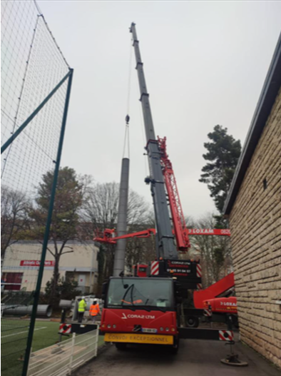 Installation du pilier d'un projecteur pour terrain de football