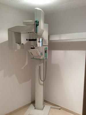 Máquina de rayos X panorámicos dentales en una sala blanca.