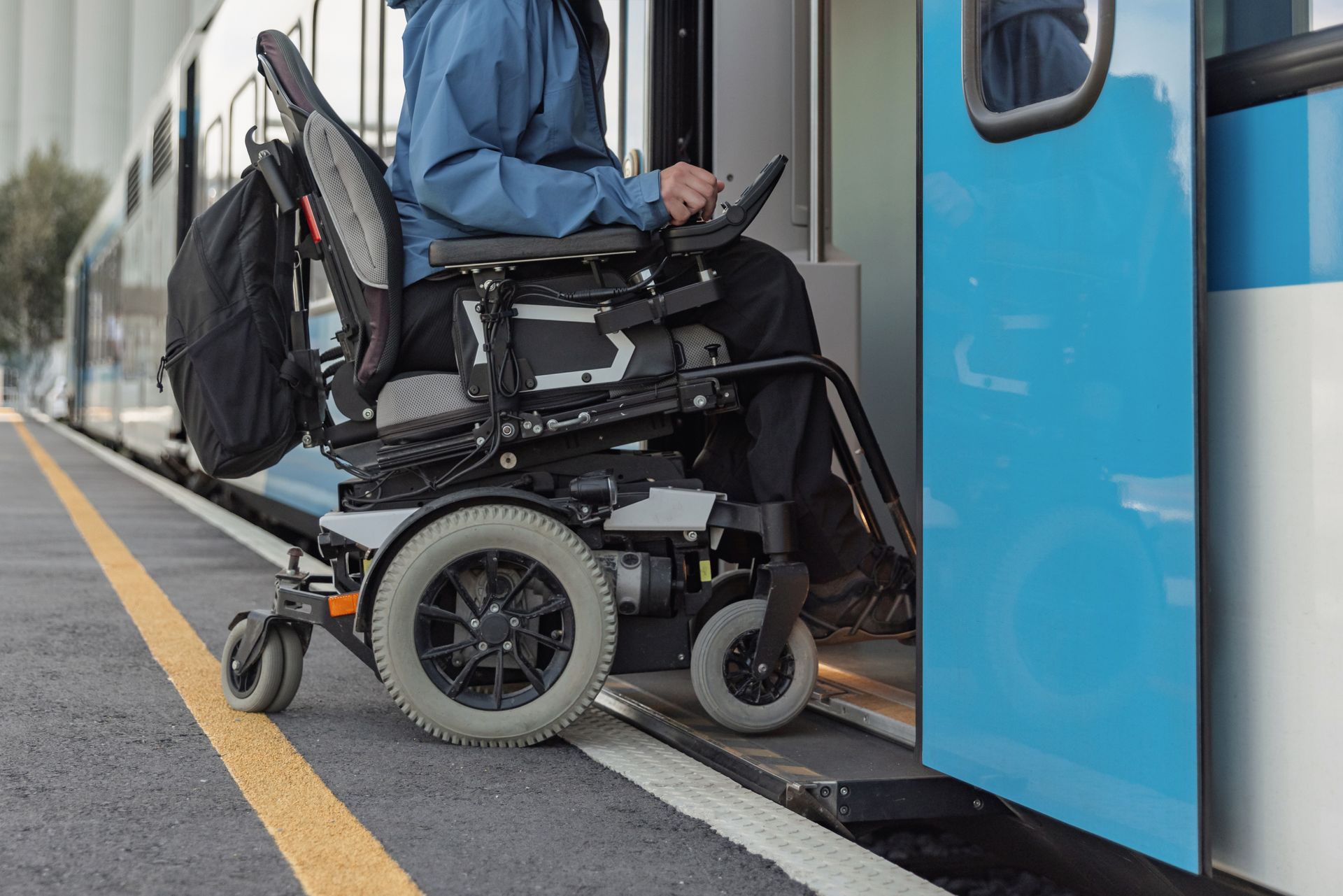 Une personne en fauteuil roulant entrant dans un tram