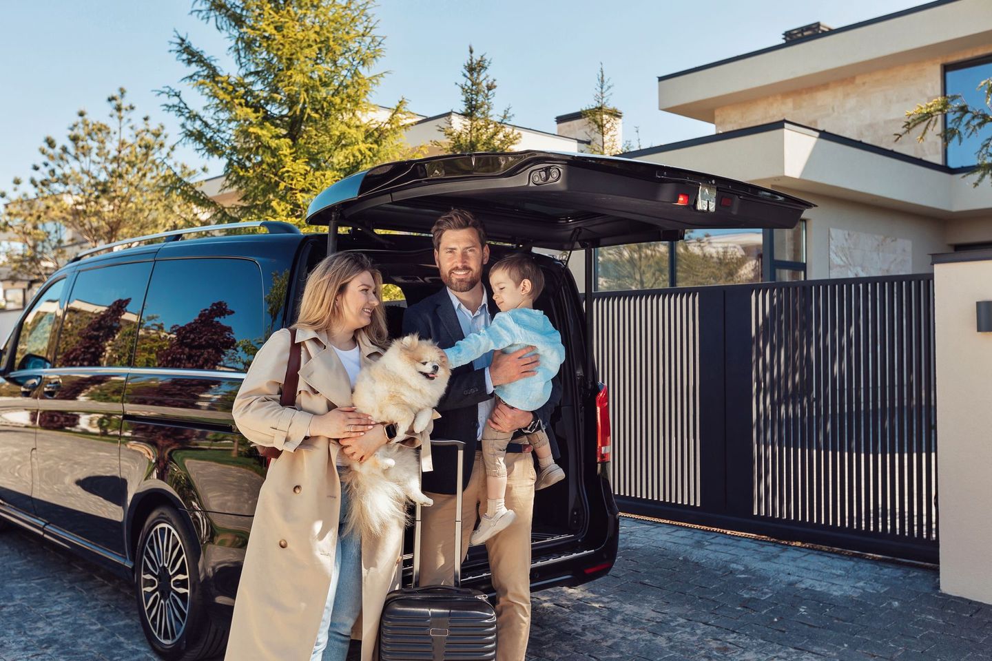 Une famille debout devant une voiture