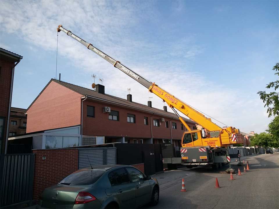 Una grulla amarilla está sentada frente a un edificio de ladrillos.
