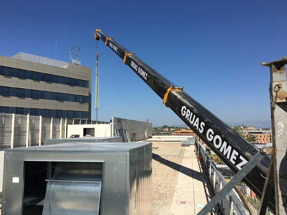 Se está utilizando una grúa para levantar una caja en la parte superior de un edificio.