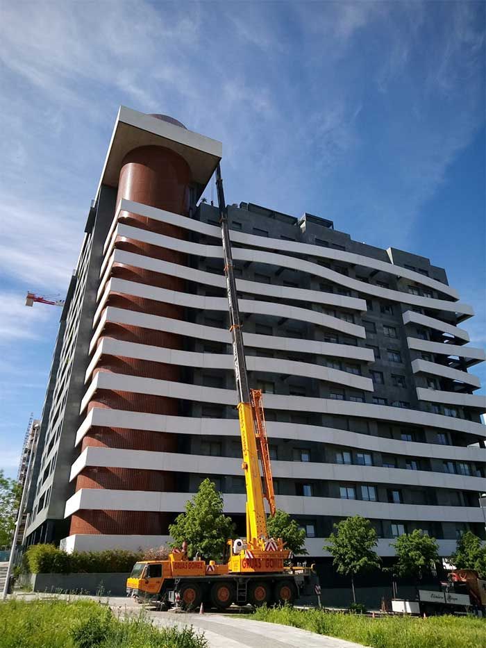 Un gran edificio con una grúa delante.