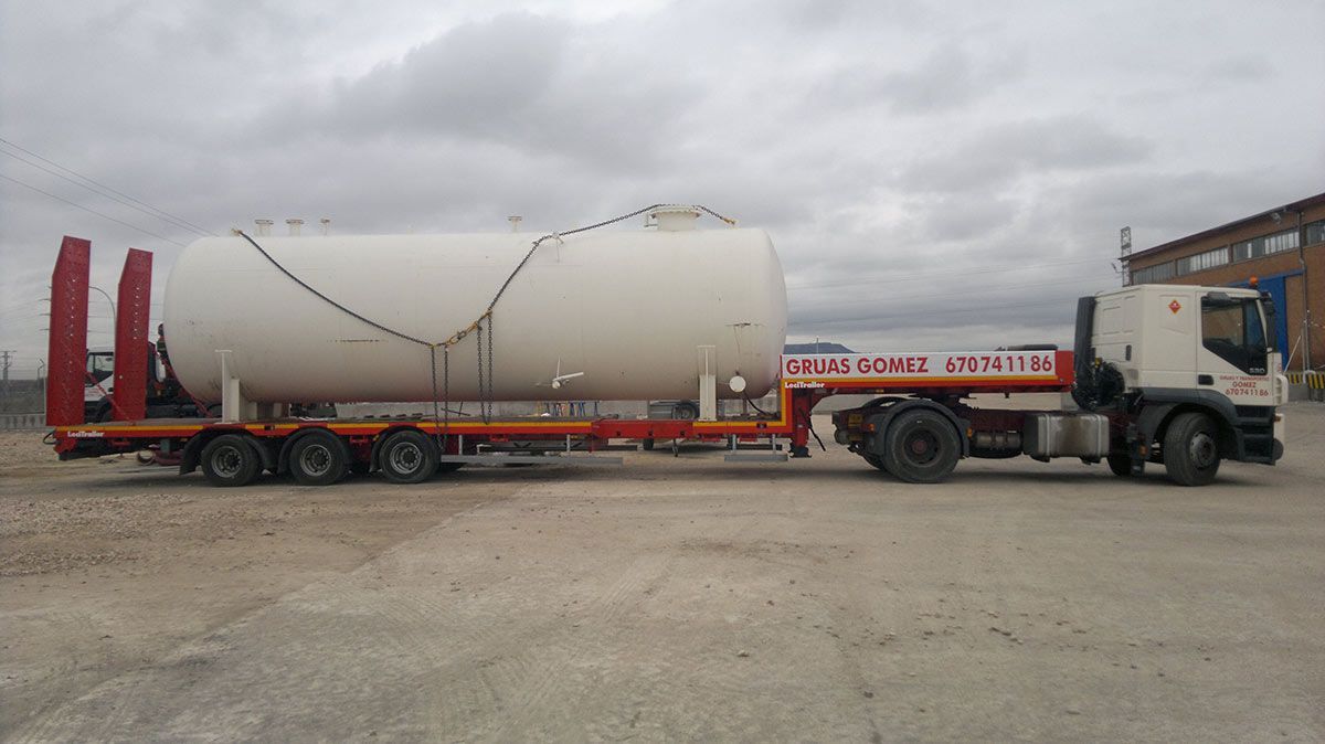 Un camión transporta un tanque grande en un remolque.