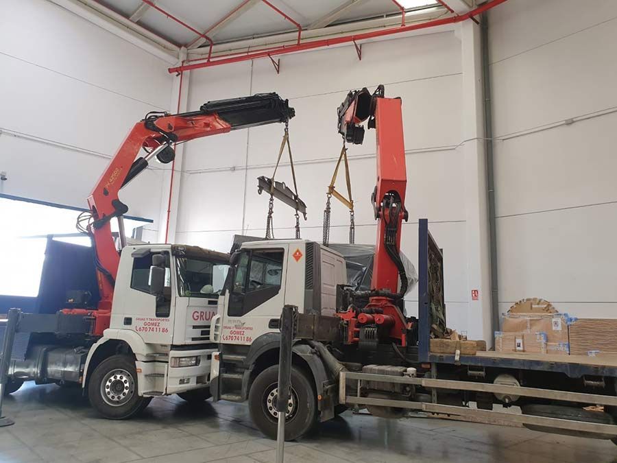 Un camión con una grúa acoplada está estacionado en un almacén.