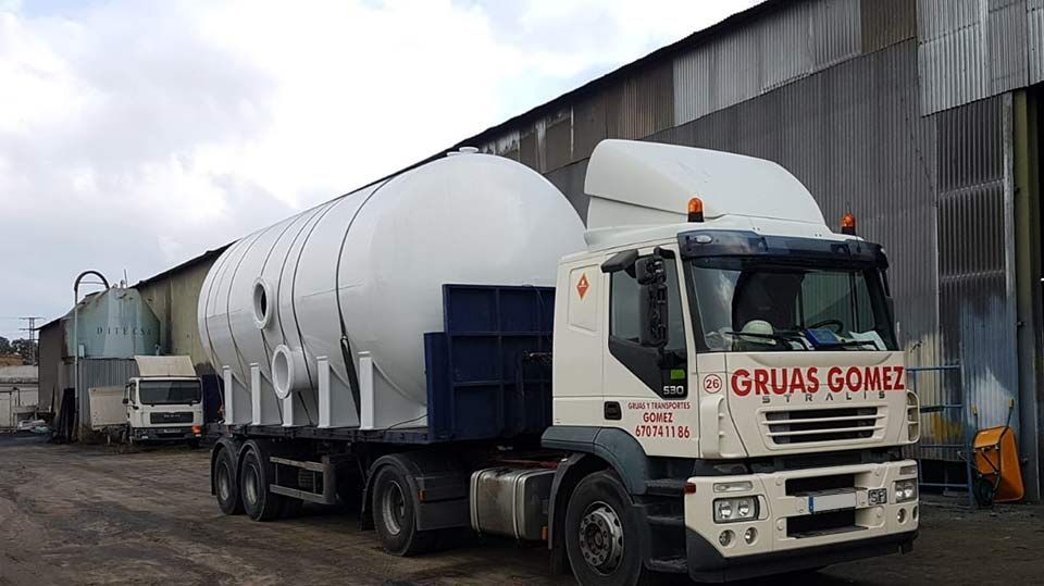 Un gran camión blanco está estacionado frente a un edificio.