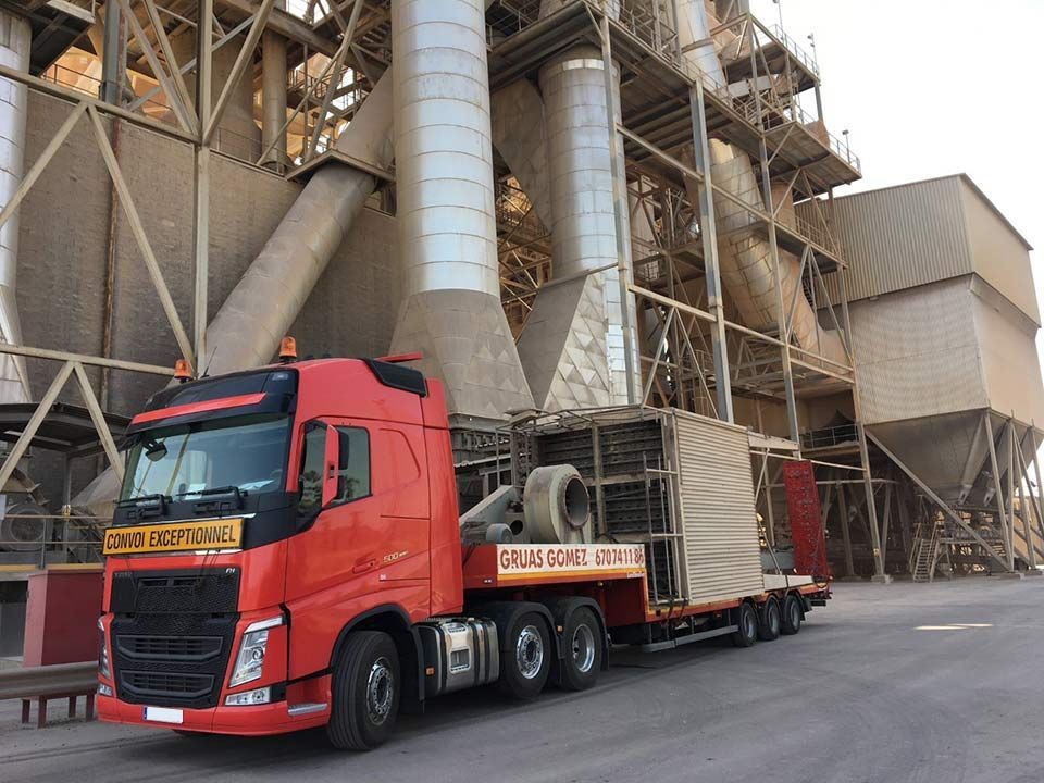 Un camión rojo está estacionado frente a un edificio grande.