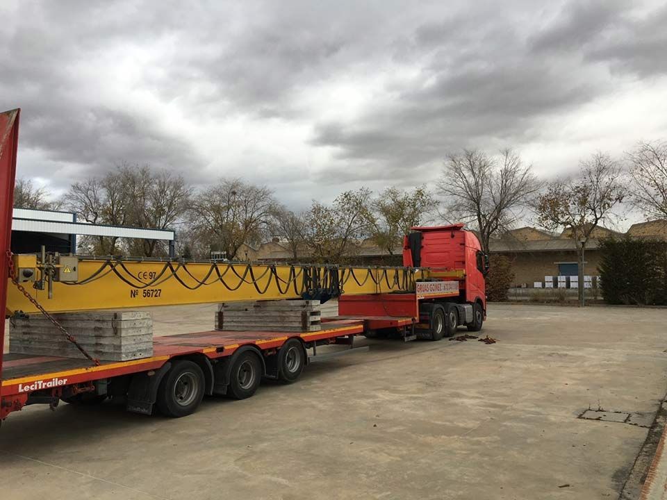 Un camión rojo con una grúa amarilla en la parte trasera está estacionado en un estacionamiento.