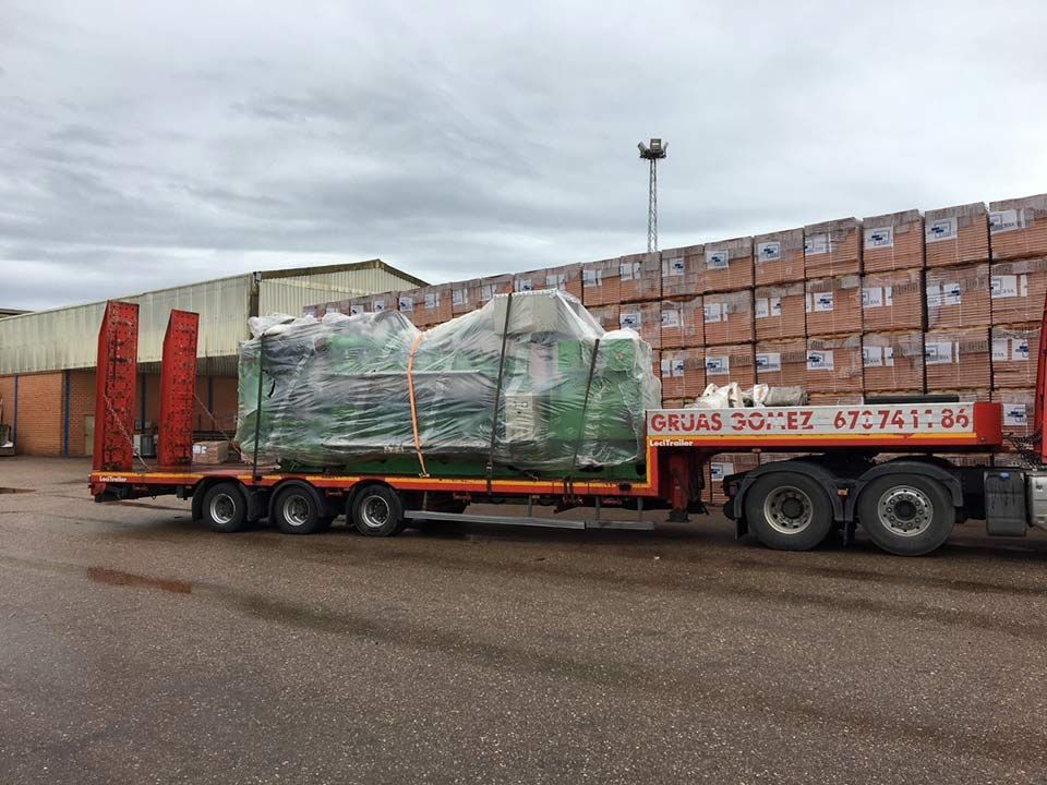 Un camión transporta una gran pieza de equipo en un remolque.