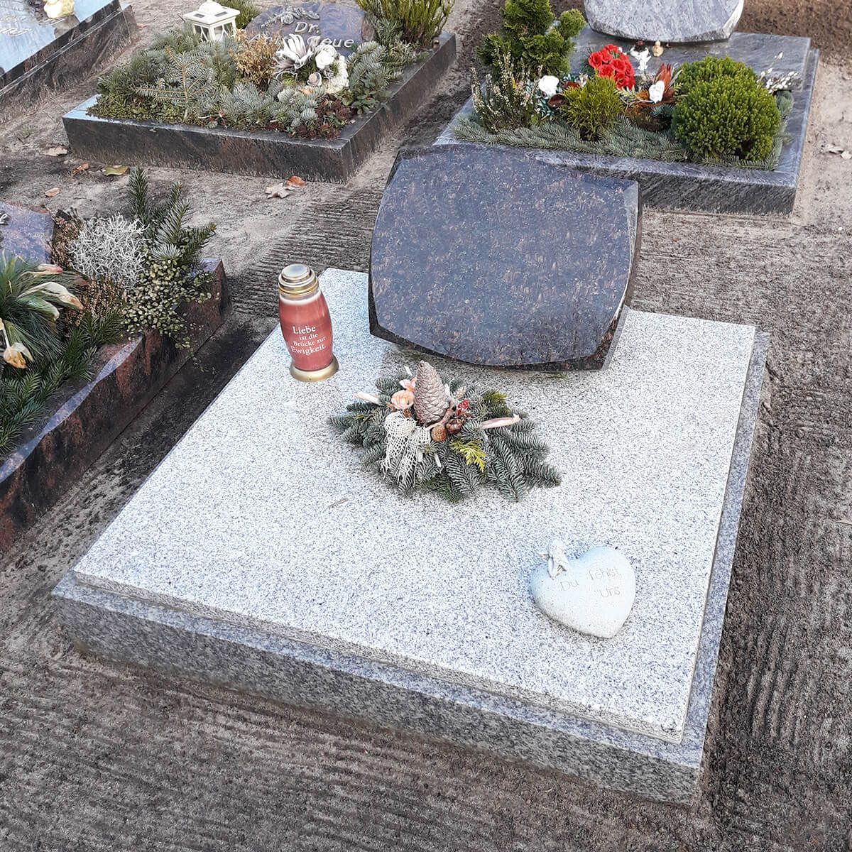 Grabmal aus Naturstein mit Umrandung