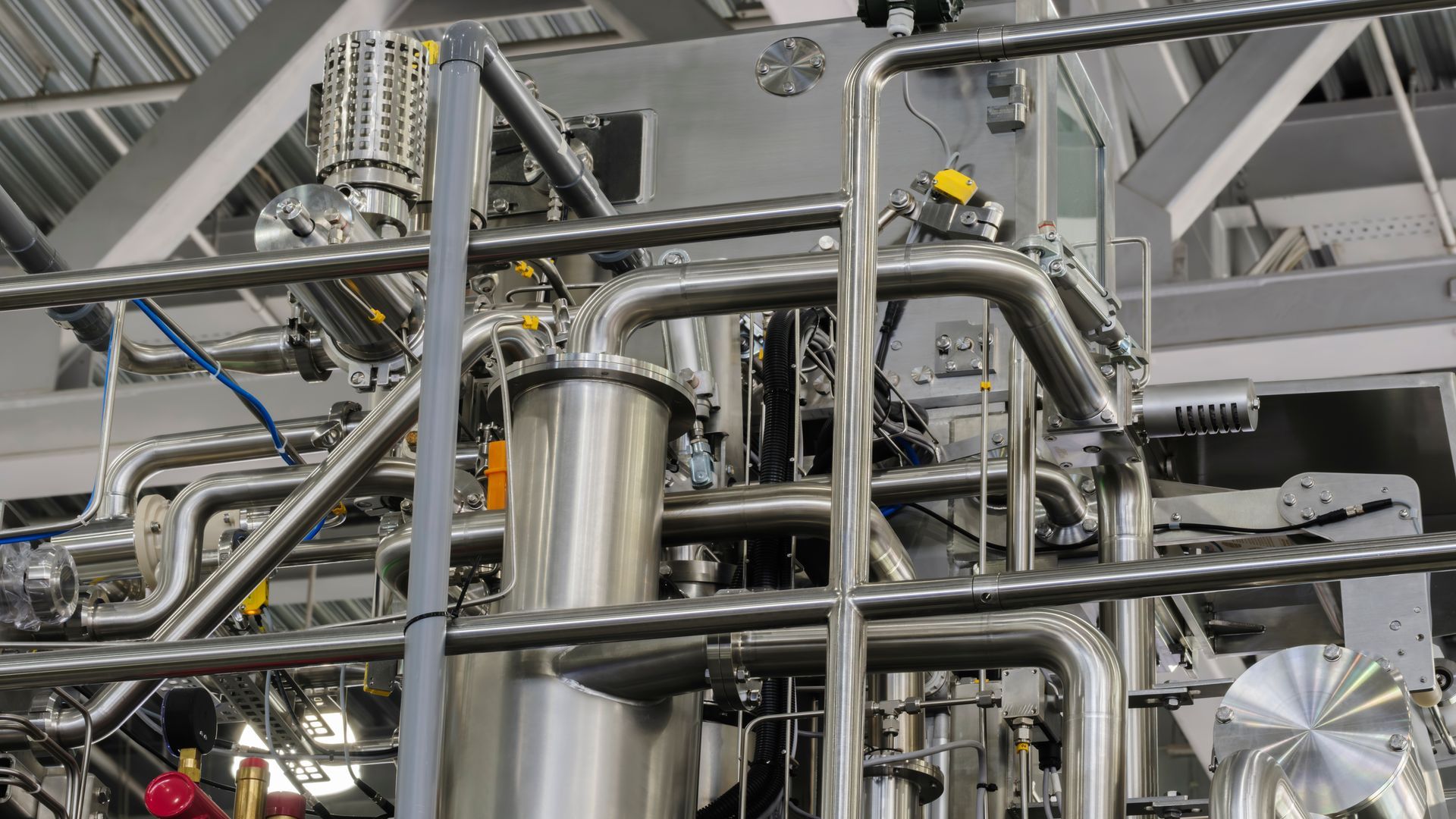 Tuyauterie et vannes industrielles en acier inoxydable dans une usine.