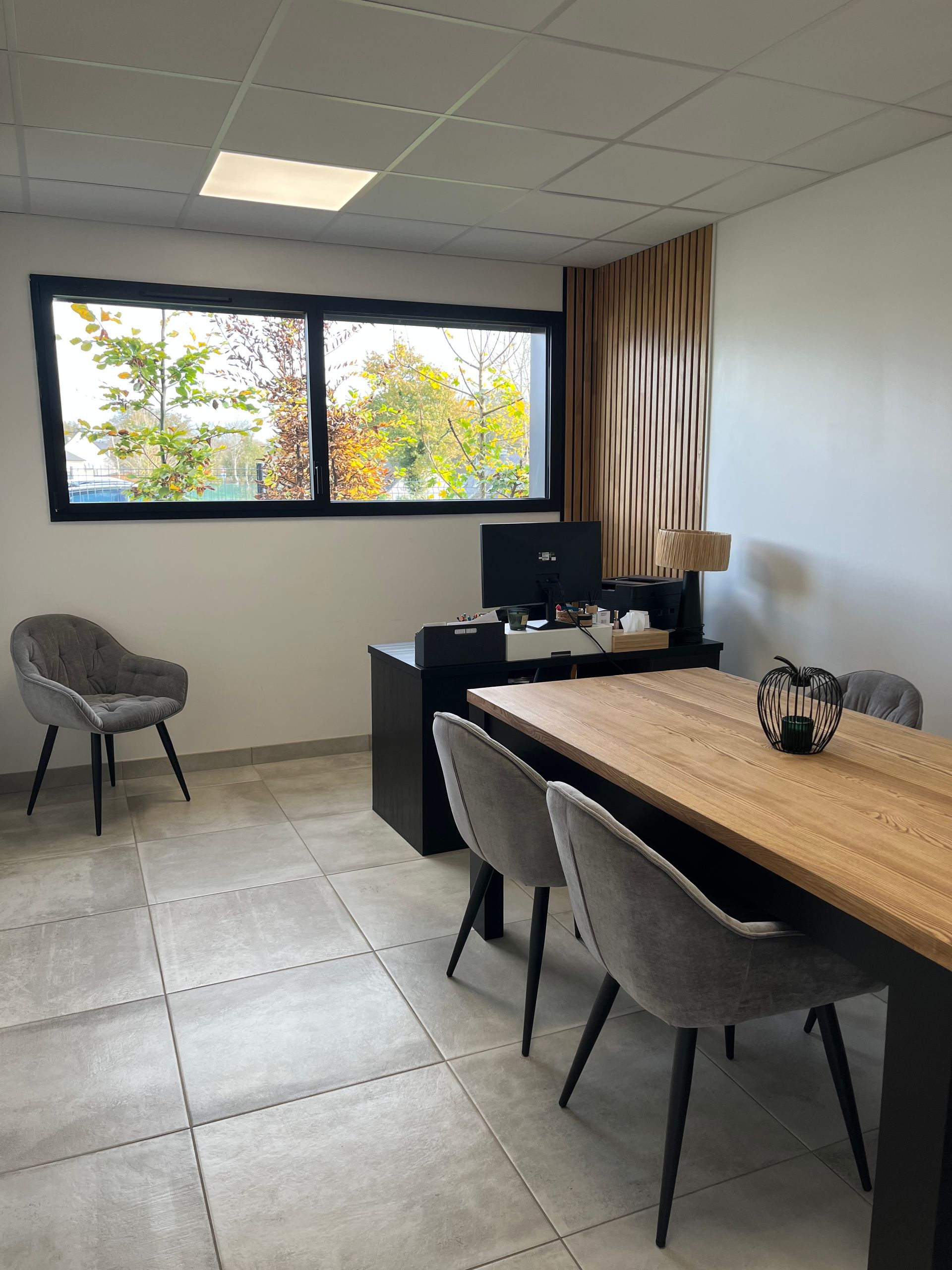 L'intérieur de notre agence de pompes funèbres à Guer, une table et des chaises ainsi qu'un ordinateur. Une cafetière est à disposition.