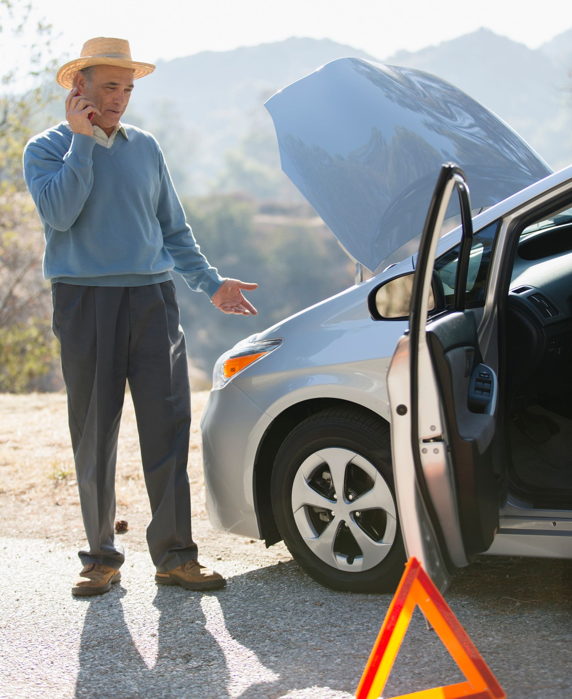 Un monsieur est en panne de voiture sur le bord de la route appelant mon taxi