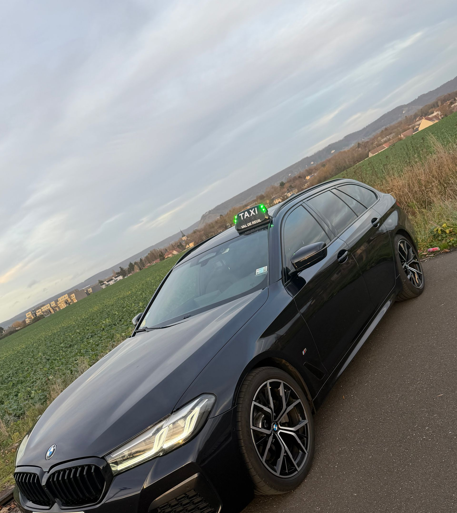 Une voiture de taxi à l'arrêt devant un champ