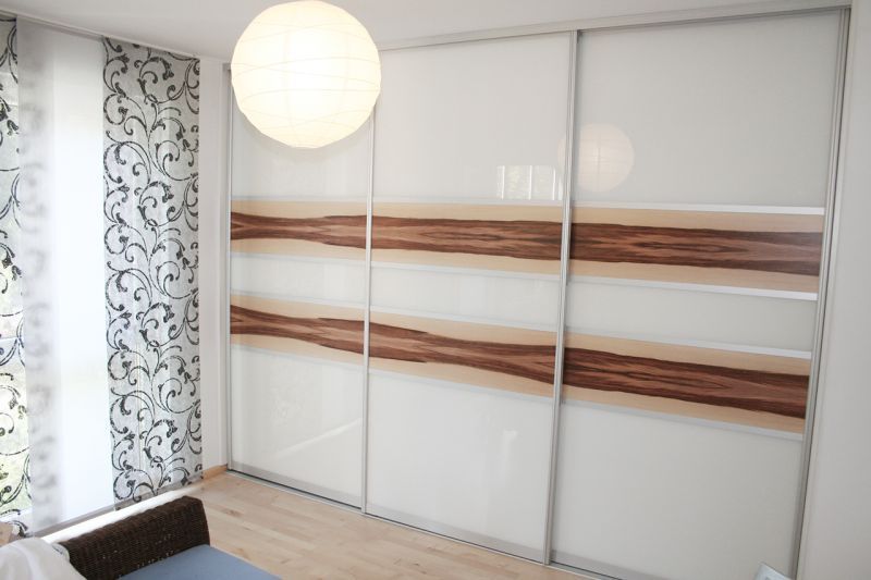 Ein Deckenhoher, heller Schrank mit leichter Holzoptik