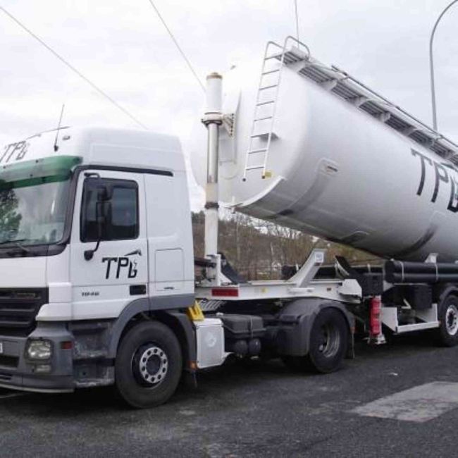 Un camión TPL blanco está estacionado al costado de la carretera.