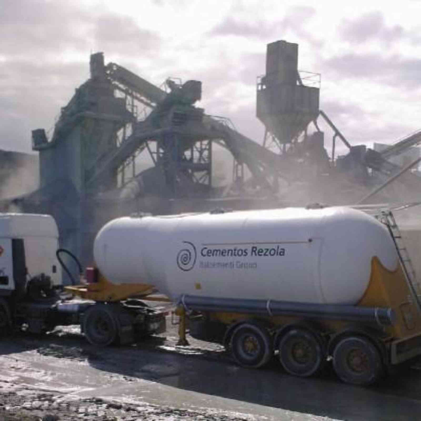 Un camión de cementos rezola está estacionado frente a una fábrica