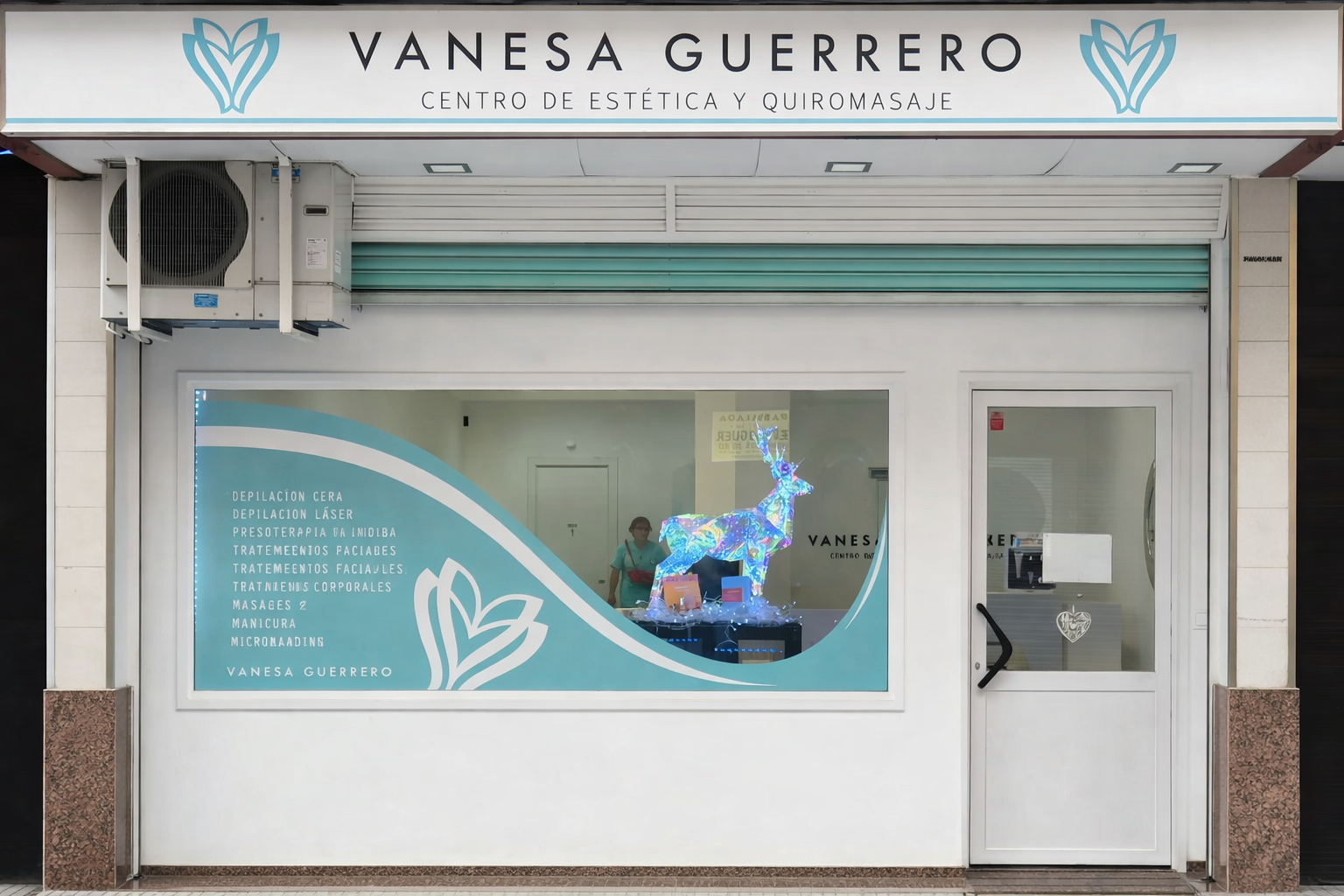 Fachada de Vanesa Guerrero, un centro de estética y masajes con letrero azul claro y una decoración con renos.