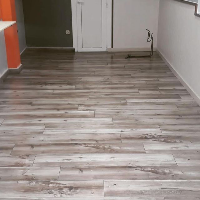 Una habitación con suelo de madera y una puerta blanca.