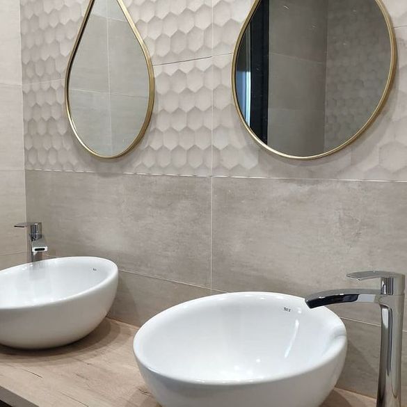 Un baño con dos lavabos y dos espejos en la pared.