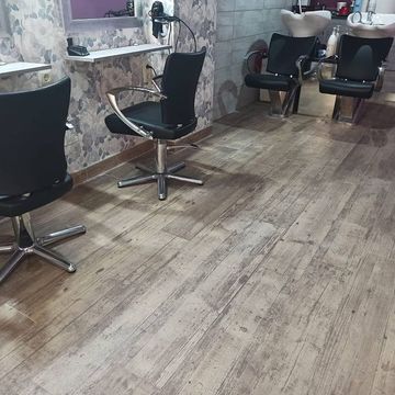 Una peluquería con dos sillas y un lavabo.