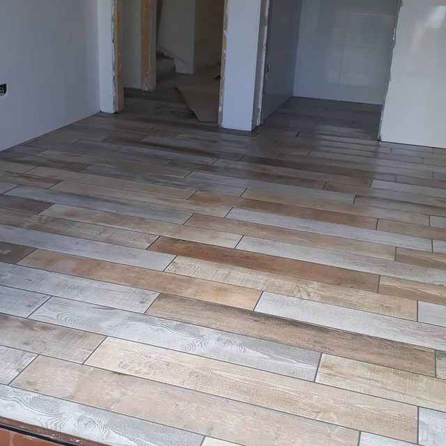 Una habitación con suelo de baldosas que parece madera.