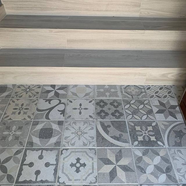 Un primer plano de un suelo de baldosas con escaleras al fondo.