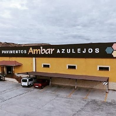 Una vista aérea de un edificio con coches aparcados delante de él.